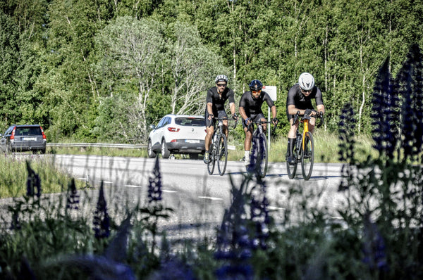 road cyclists in front of flowers