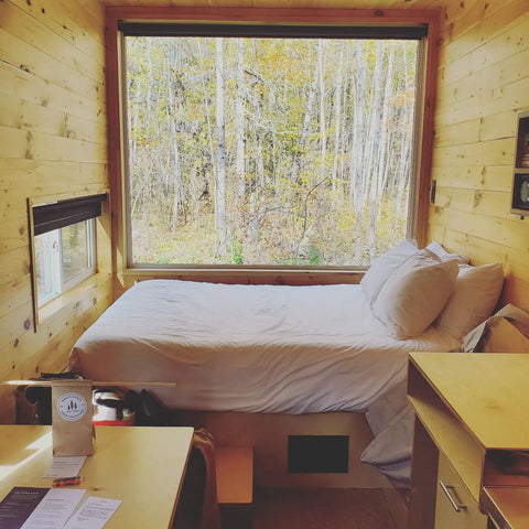 bed by window in the woods getaway solitude