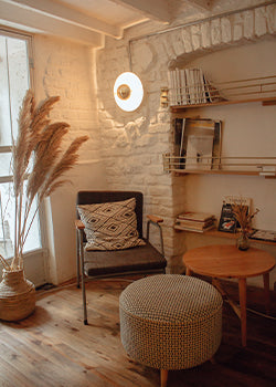 A nice well balanced room with a round foot stool 