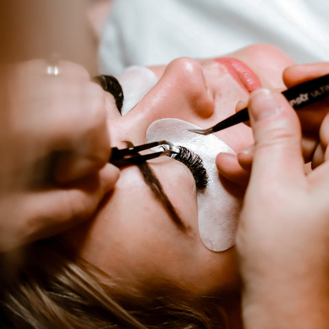 A lady is having the lash extension treatment.