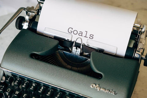 How to Make Your Resolutions Stick - Typewriter with "goals" typed out on paper