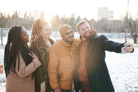 The Science of Winter Blues: Beating Seasonal Affective Disorder (SAD) - Group of friends taking a selfie in winter coats, snow on the ground
