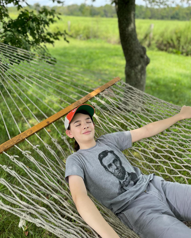 Youth on hammock wearing Abraham Lincoln hero heads t-shirt
