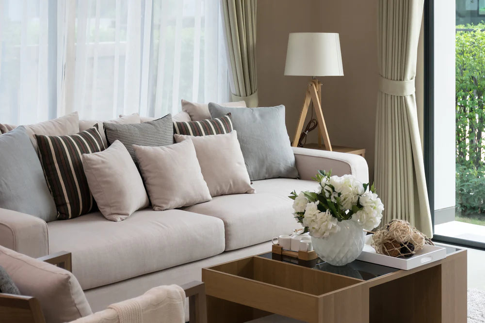 A cozy living room with a standing wood lamp and matching lampshade