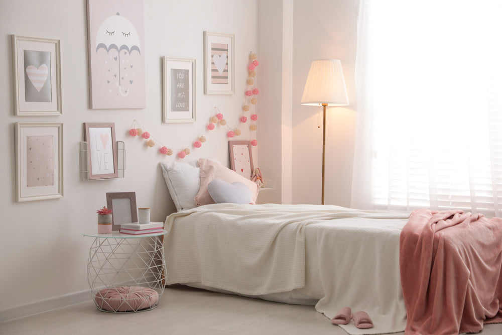 A bedroom with a warm and cozy atmosphere, with white and pink tones and a standing lamp with a warm glow