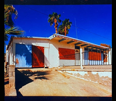 Mid-century architecture photography of an American Motel in California with blue sky and palm trees.
