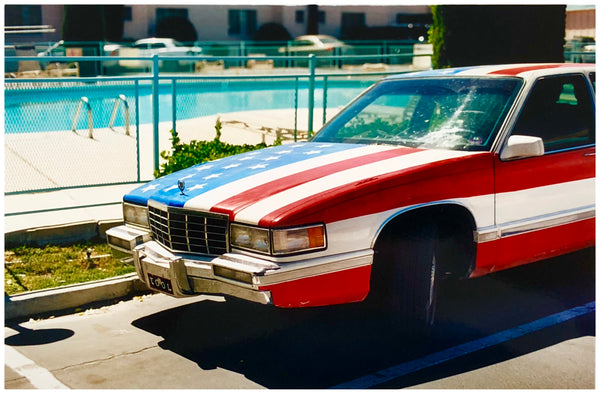 American flag painted car by the pool at a motel.