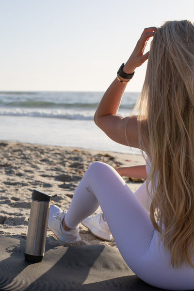 Woman at the beach with water bottle