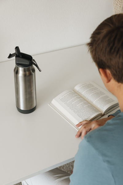 A person using a smart water bottle when reading.