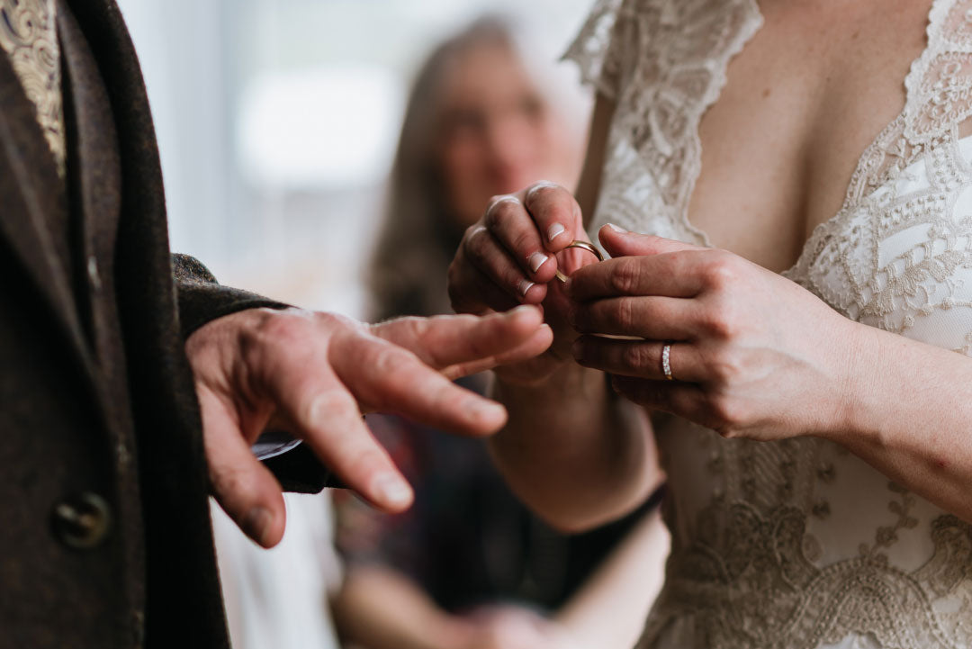 Bride putting ring on groom