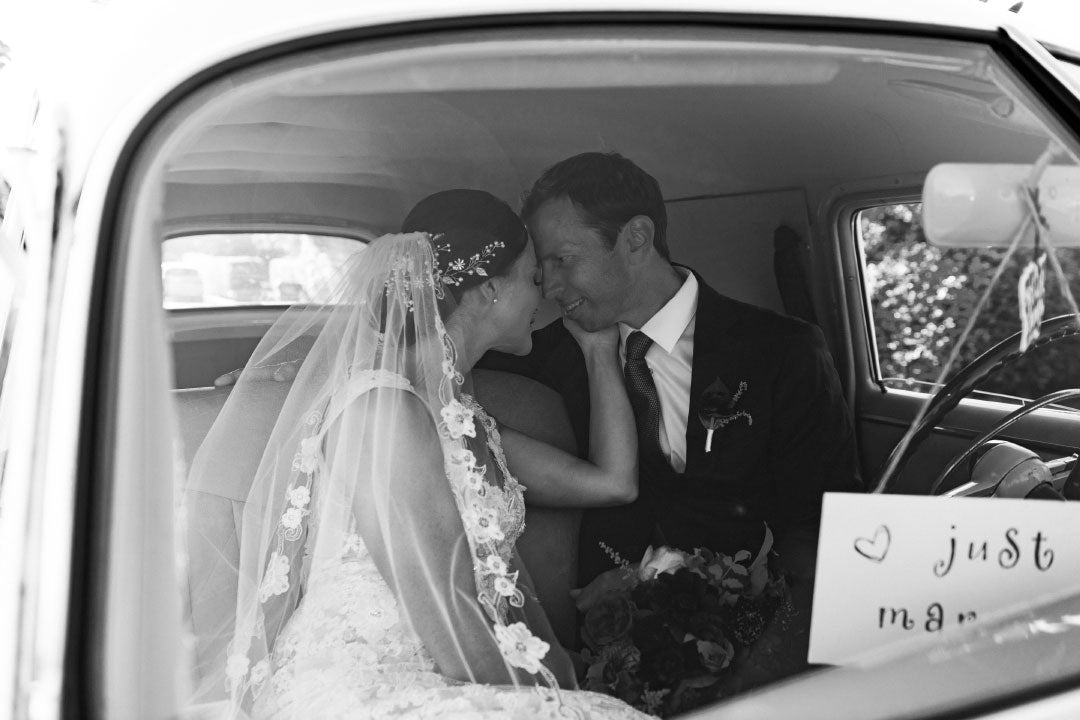 Bride and groom in just married car