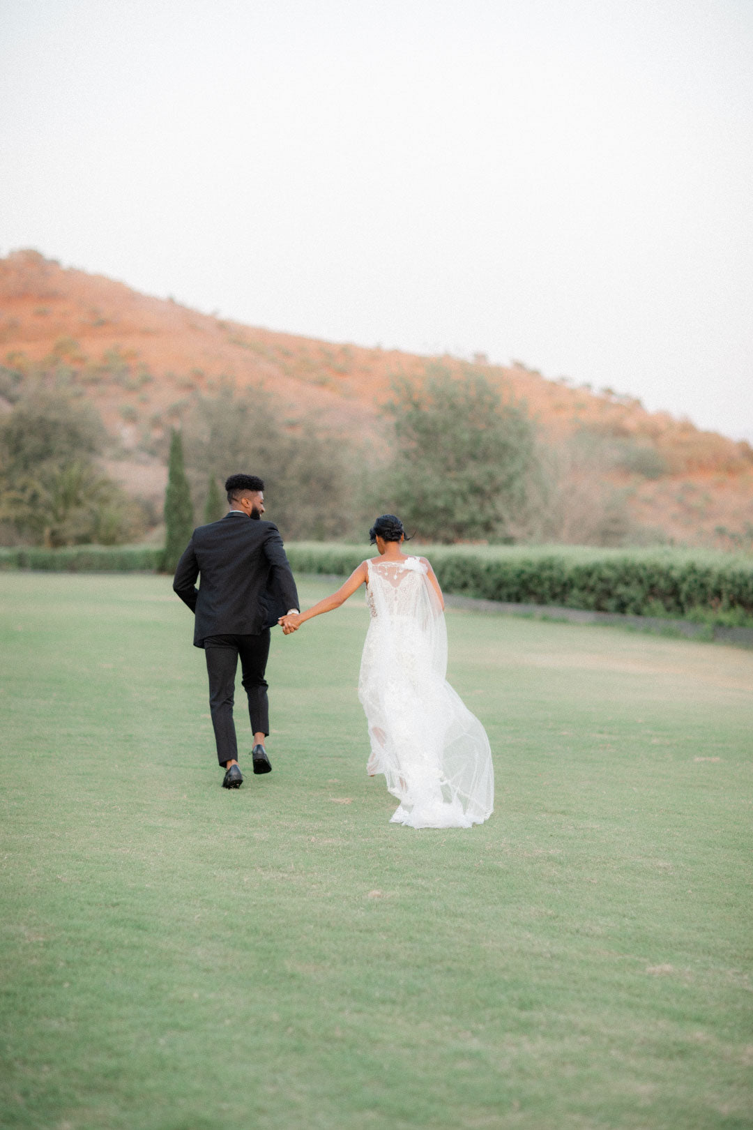 Bride and groom walking at the Wedding Venue Klenter Ranch in Grass field