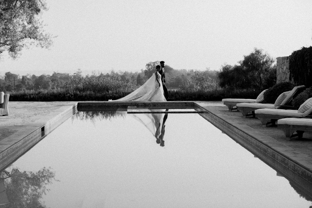 Bridal couple walk by pool