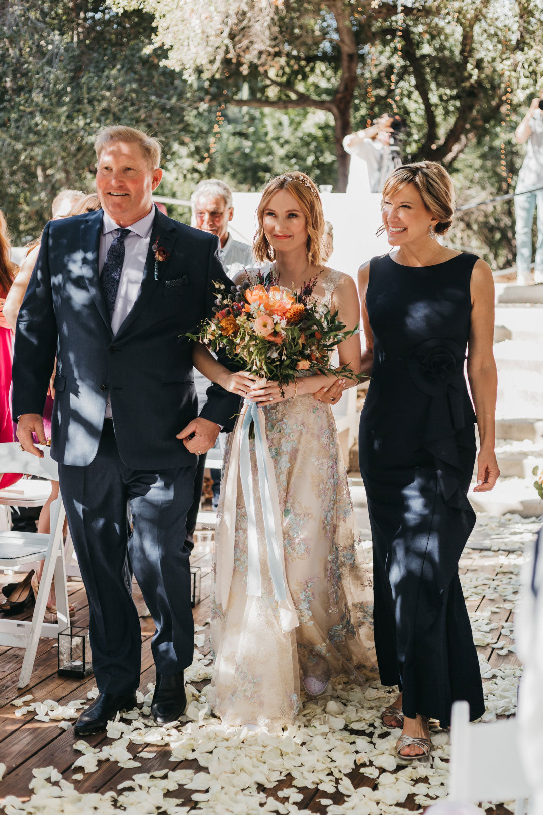 Bride walking the aisle with mother and father