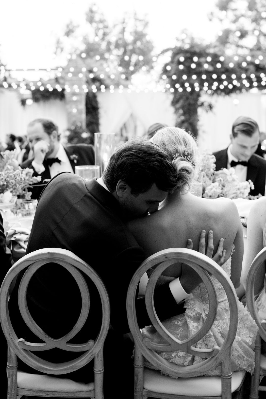 Groom kissing Brides shoulder during wedding dinner