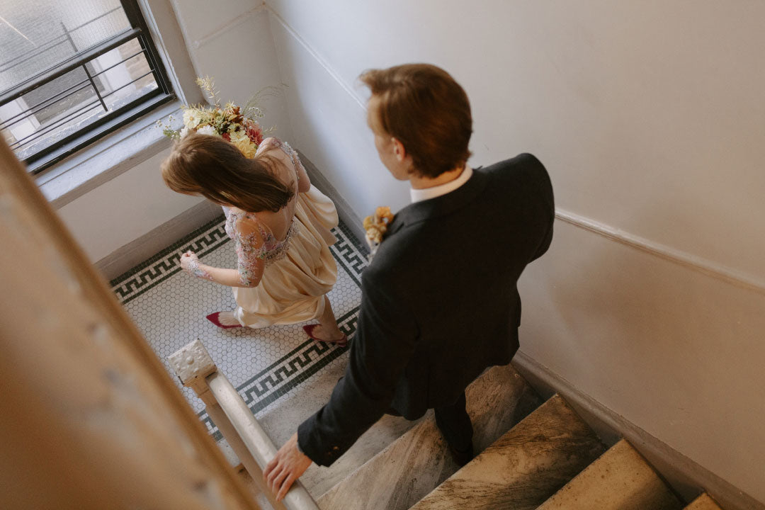 Bride and Groom walking down stairs of wedding venue