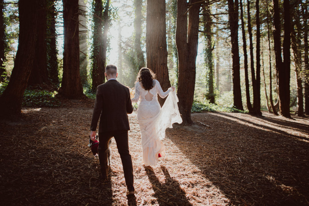 Bride and Groom walking in forrest with sunbeam streaming