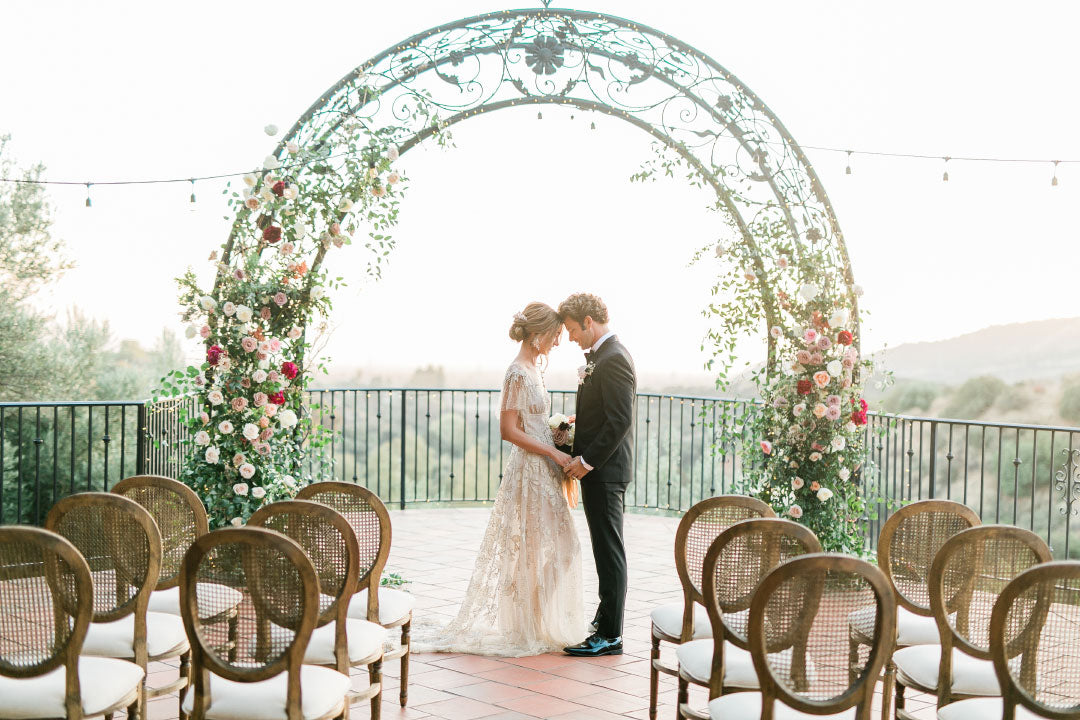 Bride and Groom under wedding arch for ceremony