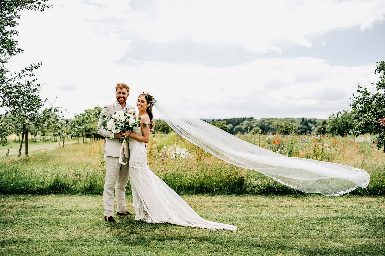 Bride and Groom posing for wedding portrait viel blowing 