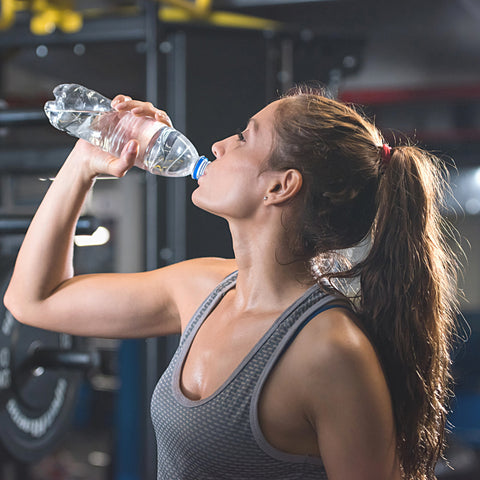 woman drinking water in the gym after kickboxing session 