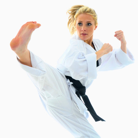 woman kicking in a gee for karate or jiu jitsu flying kick