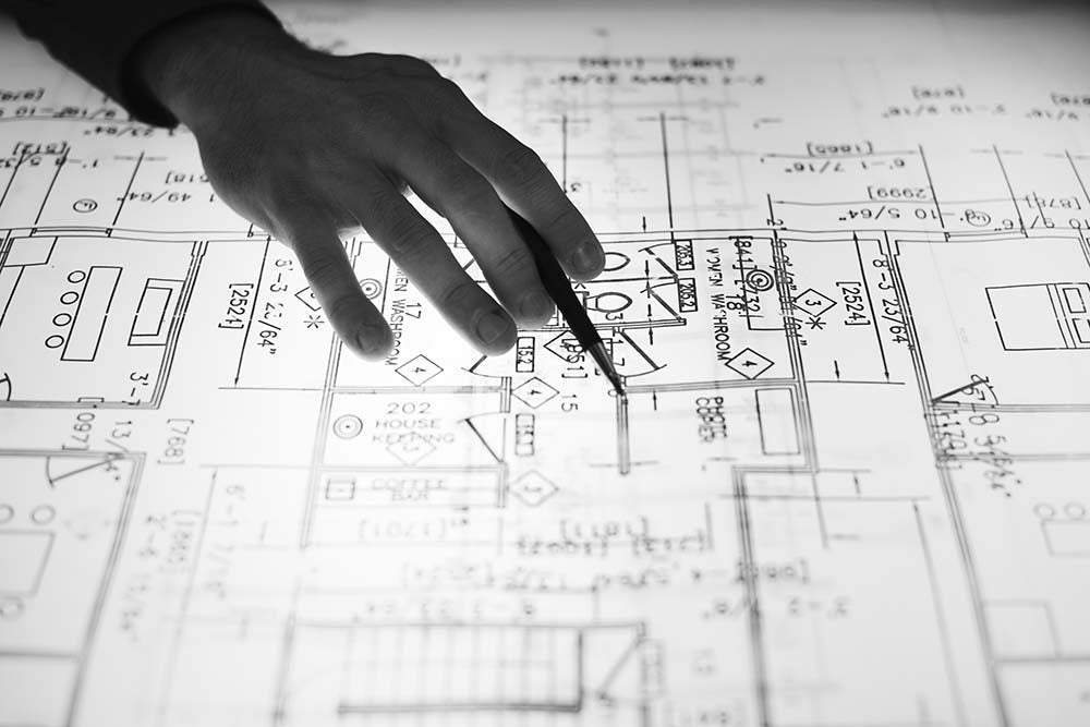 a person's hand over a blueprint