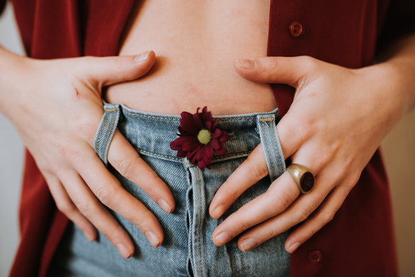 woman holding bloated abdomen 