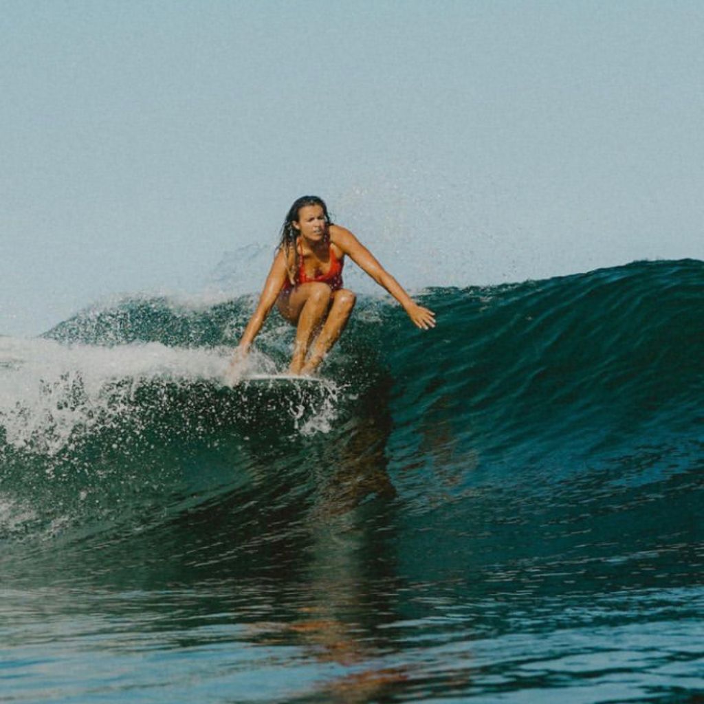 Ceri Lou from Tropicool Studio surfing a warm water wave on a longboard