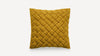 a mustard yellow cushion with braiding on the front