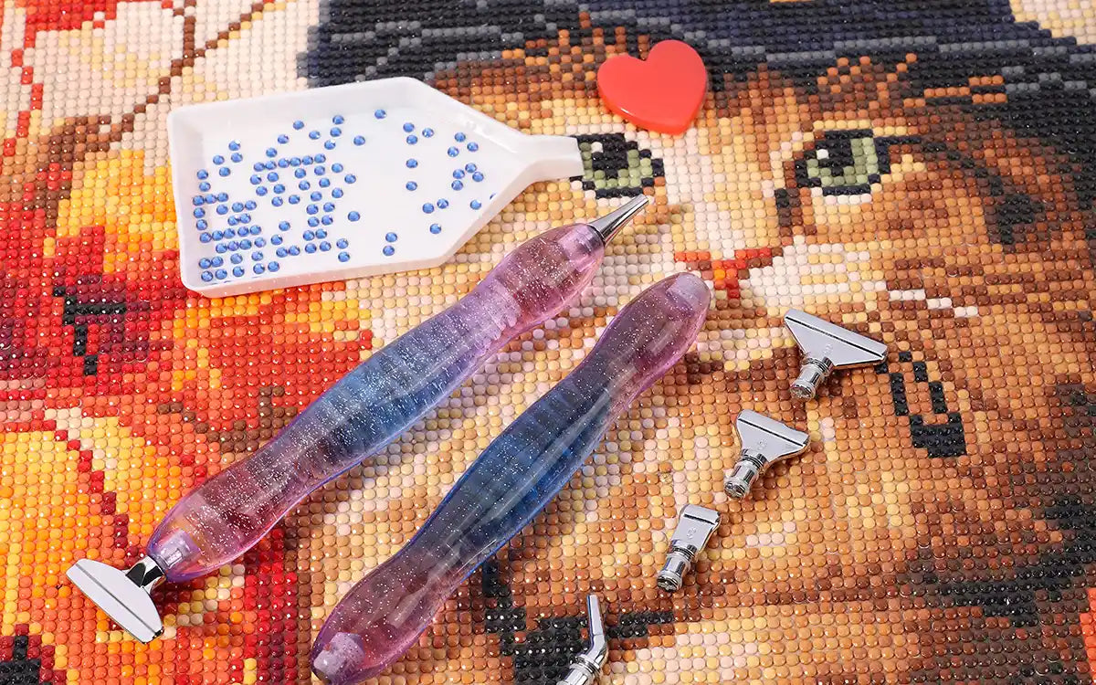 Flat lay of diamond painting kit contents including canvas, diamond drills, applicator pen, wax pad, and sorting tray – essentials for completing a full drill artwork