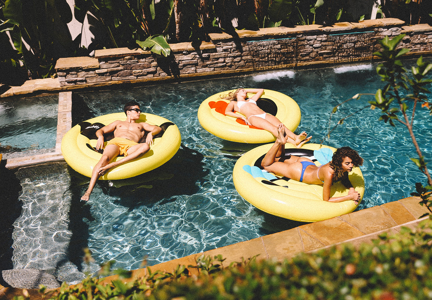 friends in a pool with pool floats