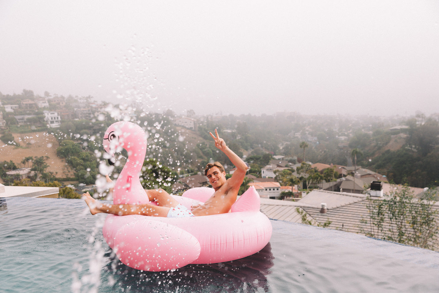 man with a flamingo pool float