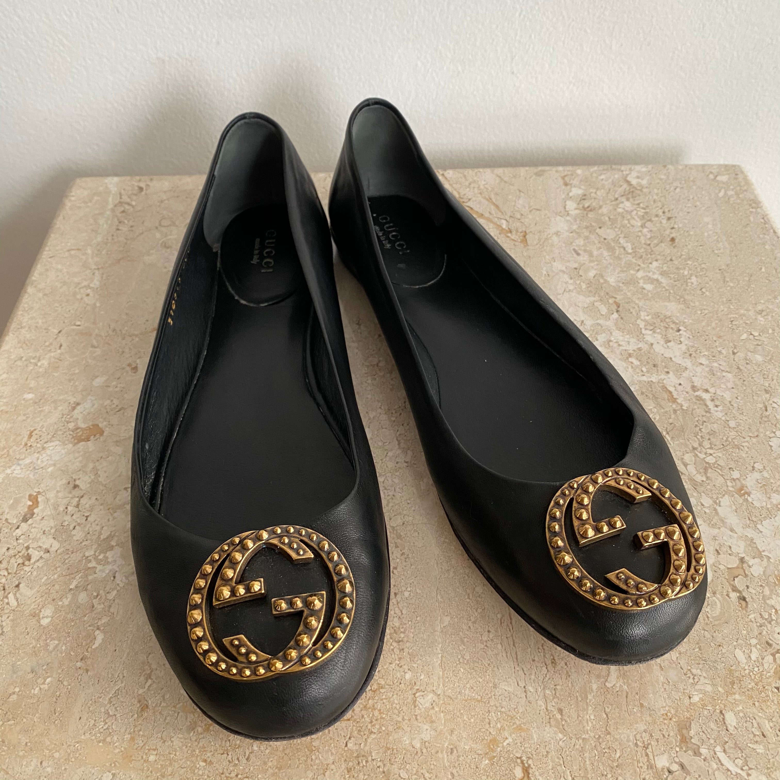 black flats with gold medallion