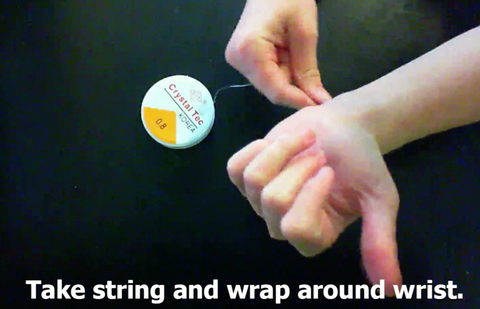 Wrap the string around your wrist. 