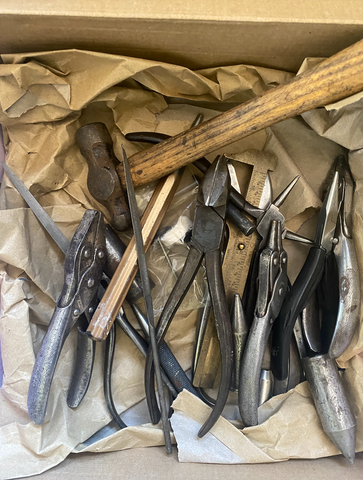 Box of pre-loved tools bought from another goldsmith. Pliers, hammer, files, punches, gauge in brown paper