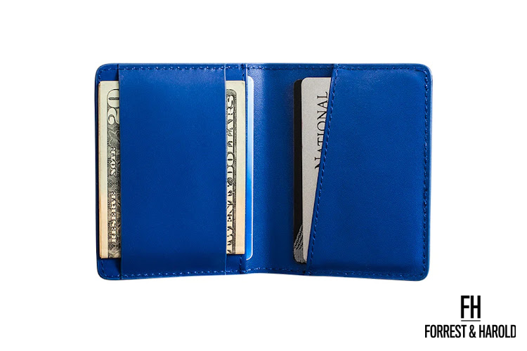 Blue money clip wallet by Forrest and Harold with a few dollars clipped