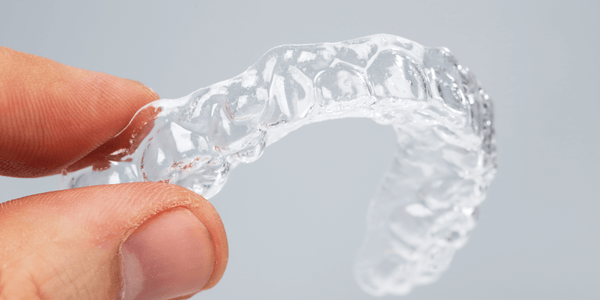 Hand holding a translucent upper essix retainer