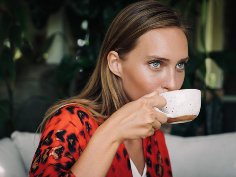 Illustration of a person enjoying a cup of coffee while wearing Invisalign.