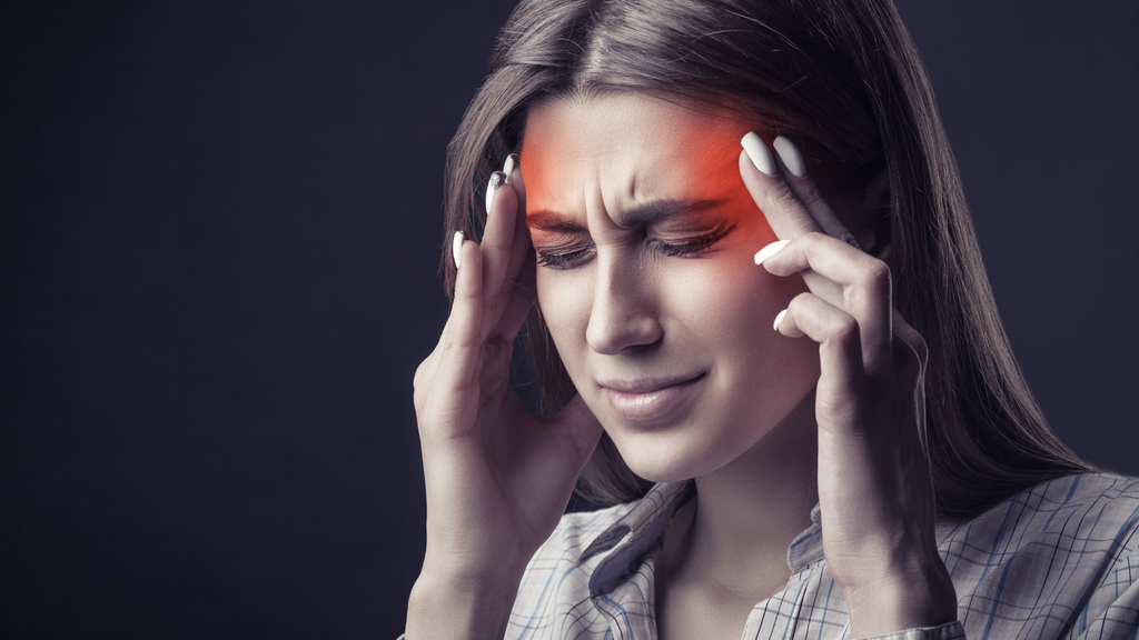 Woman showing signs of a painful headache. 