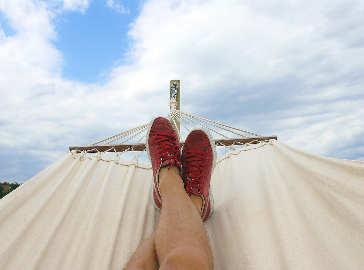 A person's legs on a hammock.