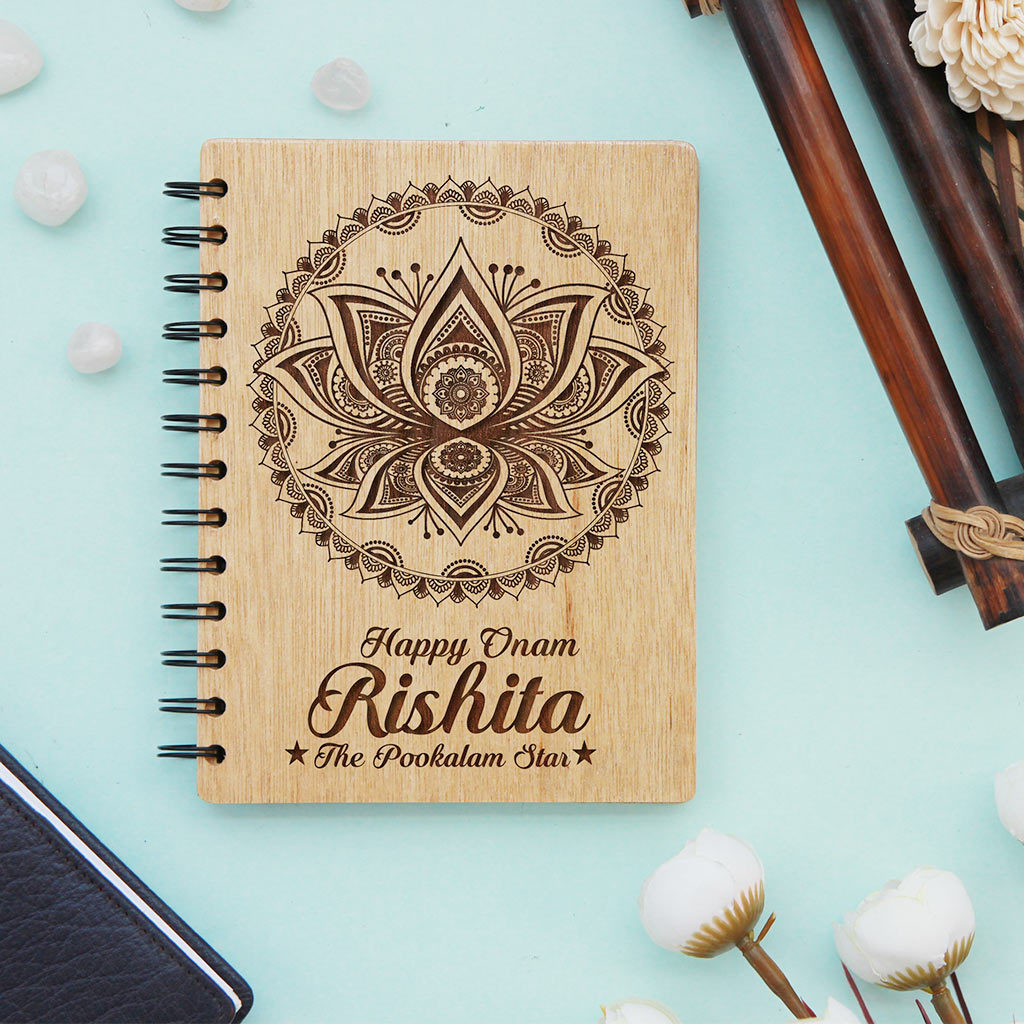 Happy Onam Wooden Notebook Engraved With Pookalam. This Spiral Notebook Makes The Best Onam Gifts. This Personalised Gift Can be engraved with onam wishes in malayalam.