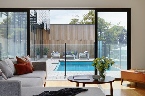 brown sofa near glass window and pool