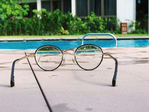 eyeglasses beside a pool