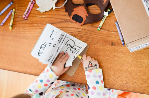 Girl coloring in her mini bear coloring book from her cute kid's gift package. Shows what pages look like.