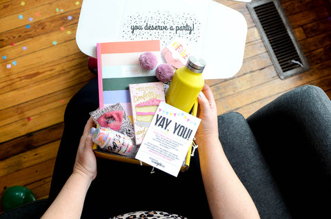 Yay You Congratulations Gift Idea: person holding open gift box on couch