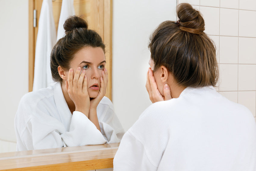 Woman examining dark circles under the eye