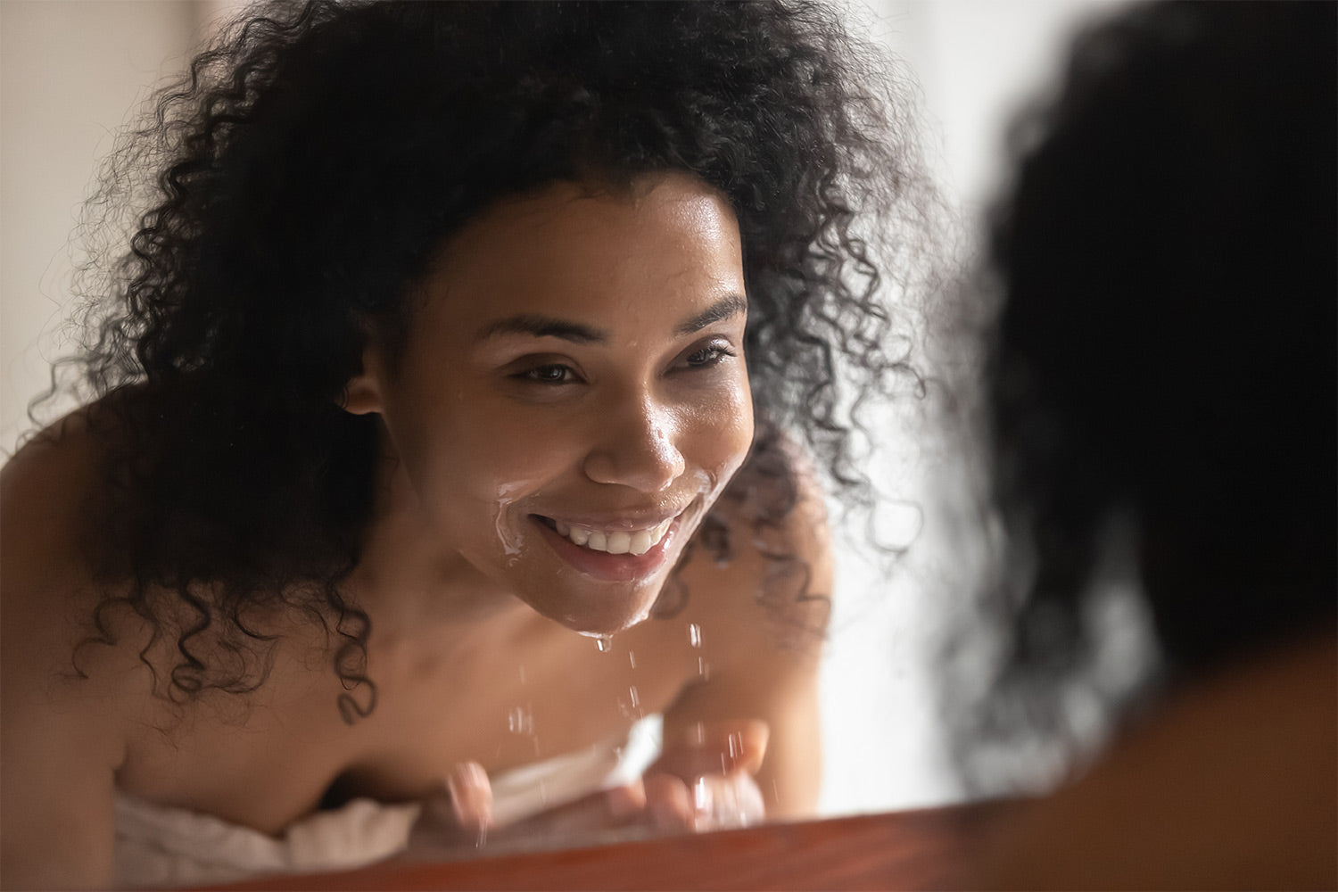 woman washing her face with facial cleanser