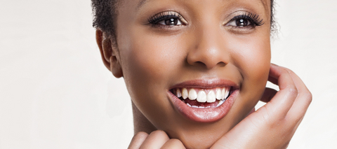 Diverse woman smiling while holding her face
