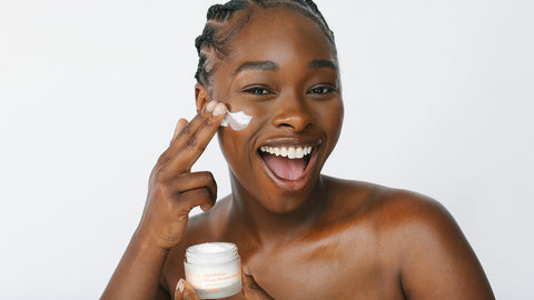 African American model holding HydraBalance Instant Moisture Infusion near her face while smiling