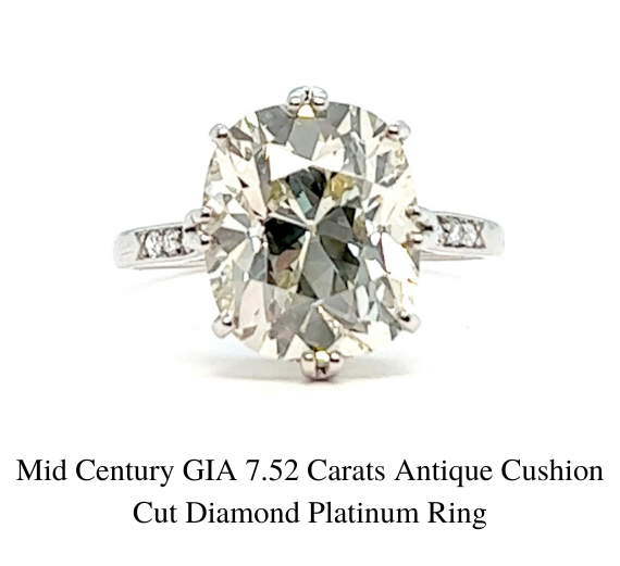 中世纪 7.52 克拉古董垫形切割钻石铂金戒指的特写，白色背景上铺有镶钻戒指。